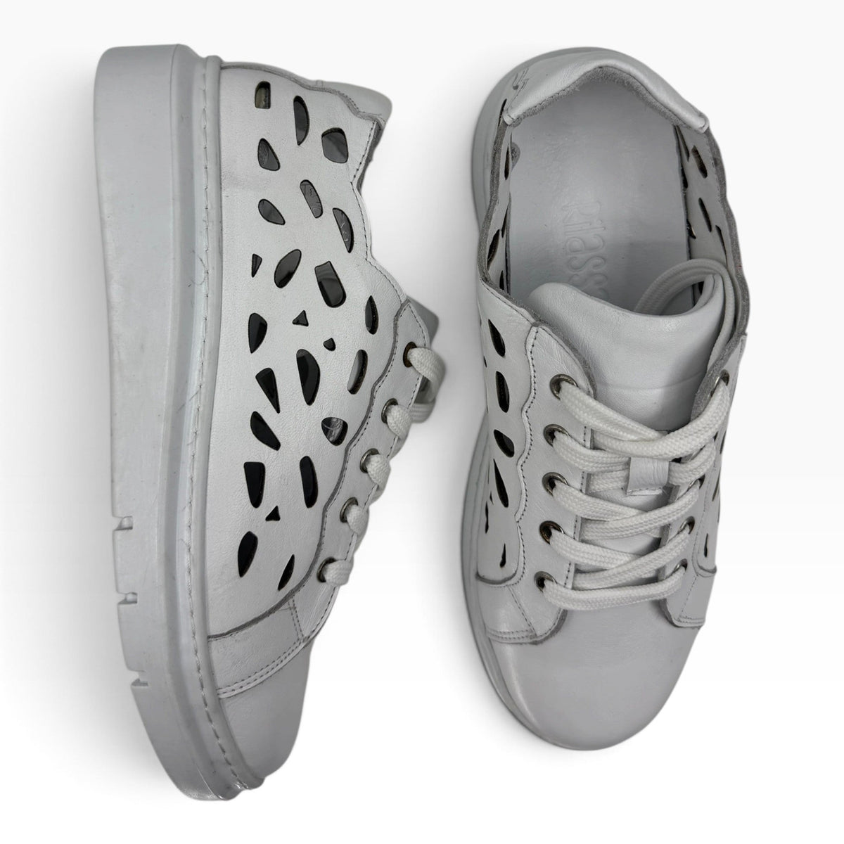 The Shoe Shop Tira white leather sneakers featuring a stylish laser-cut geometric pattern and lace-up closure.