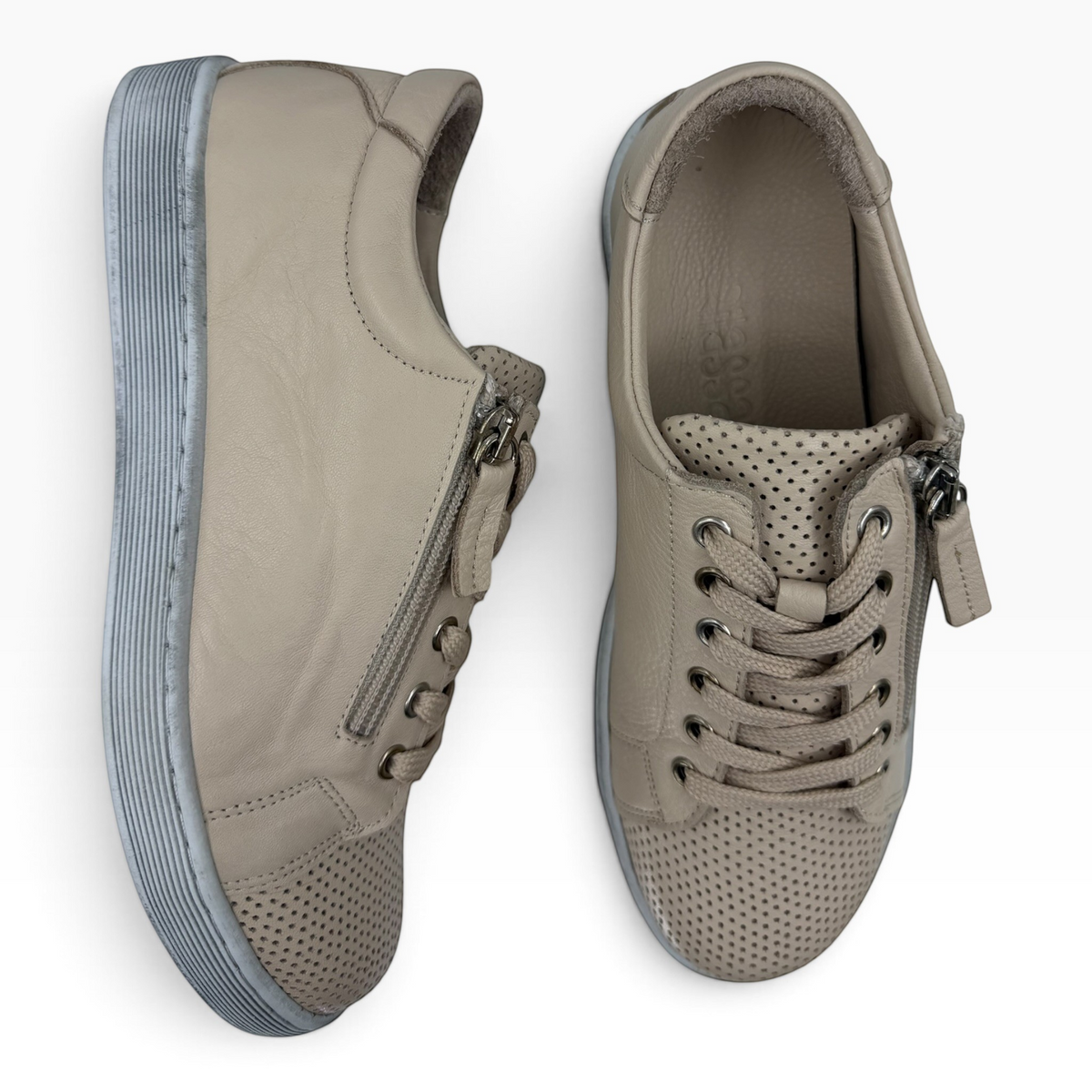 The Shoe Shop Tommie Perf beige leather sneakers with perforated detailing, lace-up front, and side zip closure.