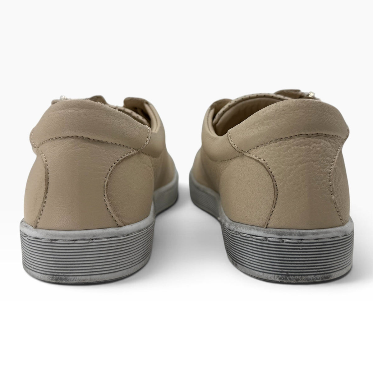 The Shoe Shop Tommie Perf beige leather sneakers viewed from the back showing textured rubber soles