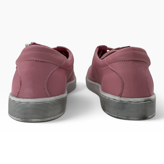 Rear view of The Shoe Shop Tommie Perf pink leather sneakers with textured rubber soles on a white background