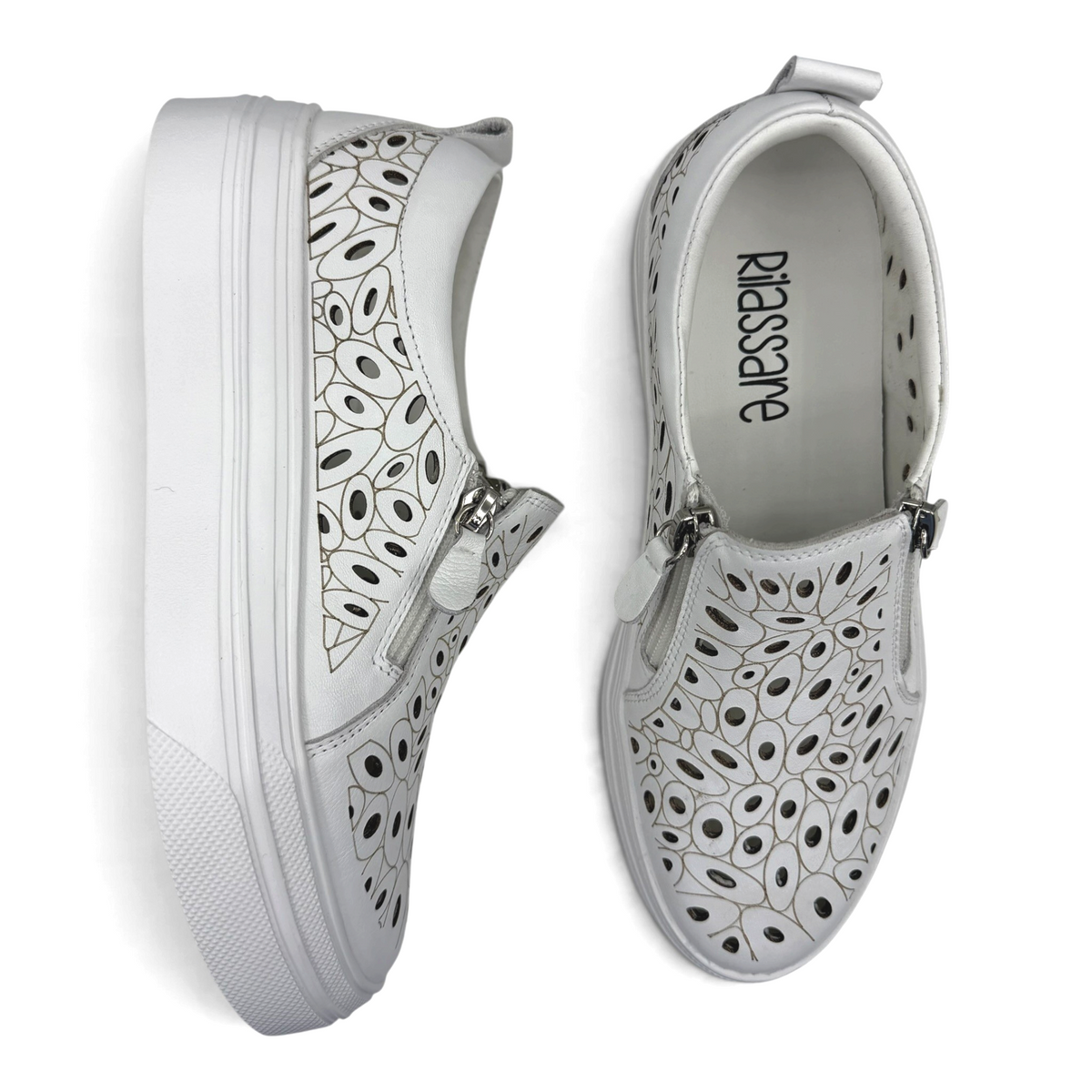 The Shoe Shop Triffic white leather sneakers with laser-cut floral patterns, side zips, and platform rubber soles.