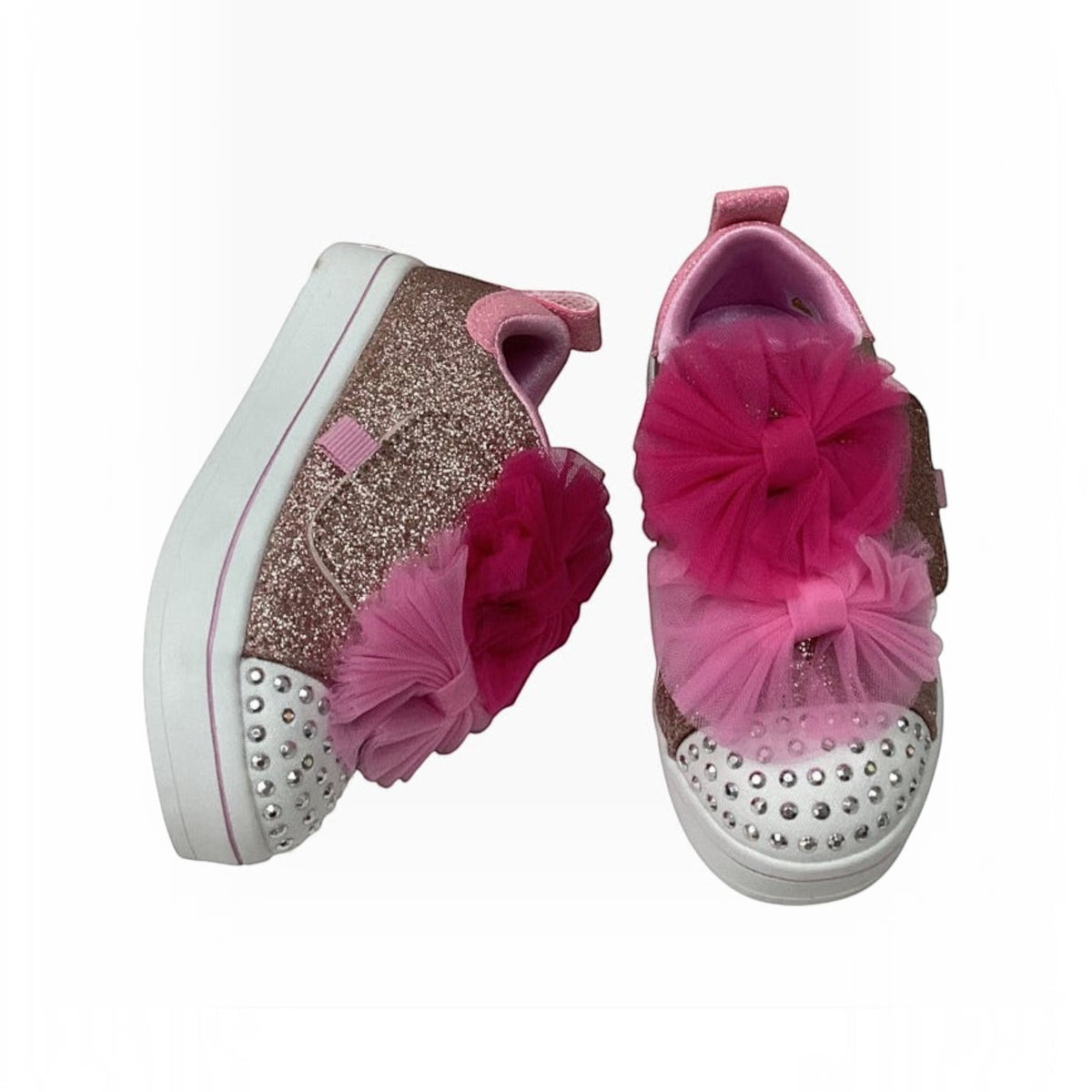 The Shoe Shop Twinkle Toes glitter sneakers with pink tulle bows, rhinestone toe caps, and adaptive closure straps.
