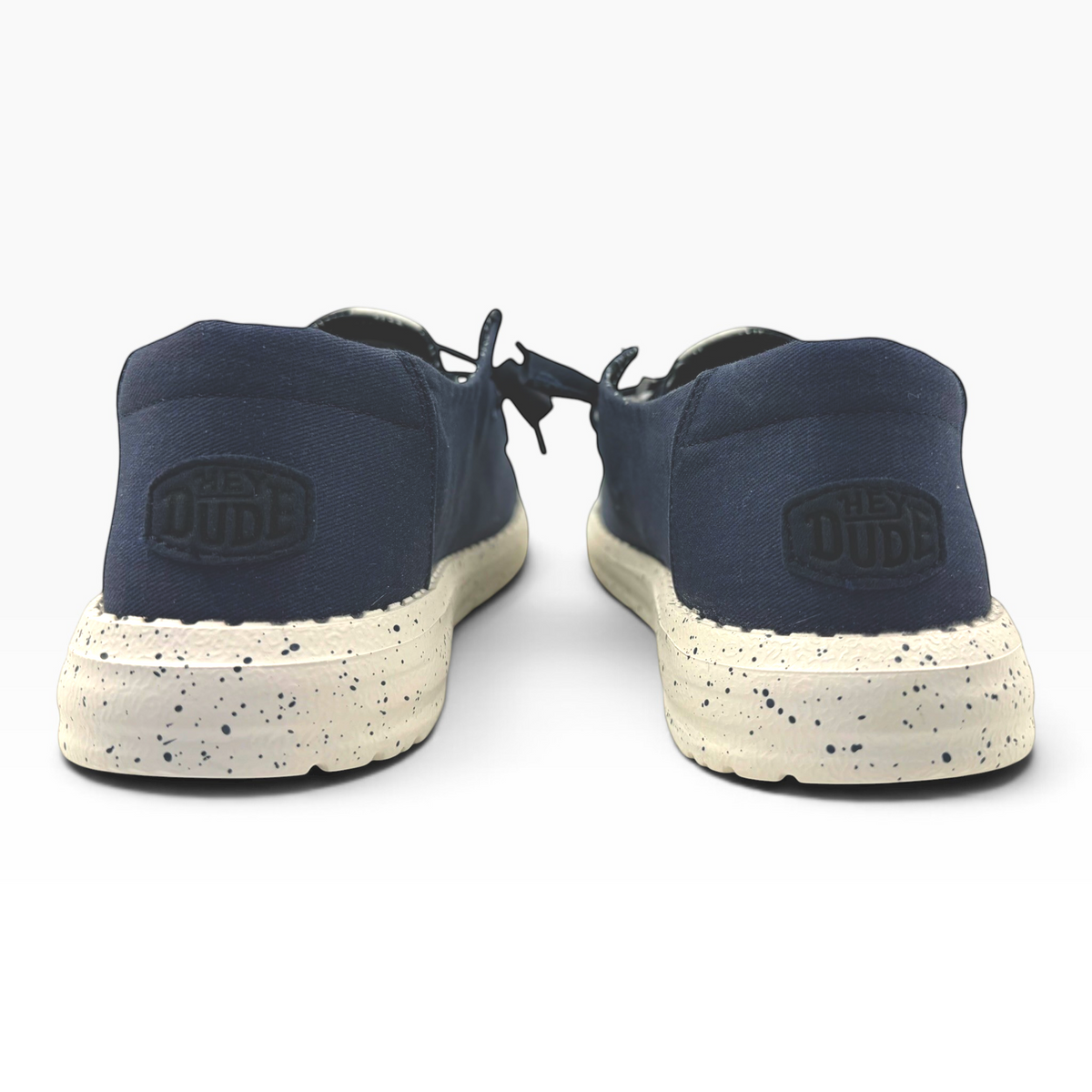The Shoe Shop Wendy Stretch navy blue slip-on shoes with a speckled white sole and Hey Dude heel branding