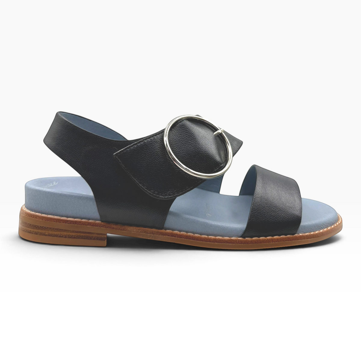 The Shoe Shop Willa black leather flat sandal with a large silver circular buckle and light blue cushioned footbed