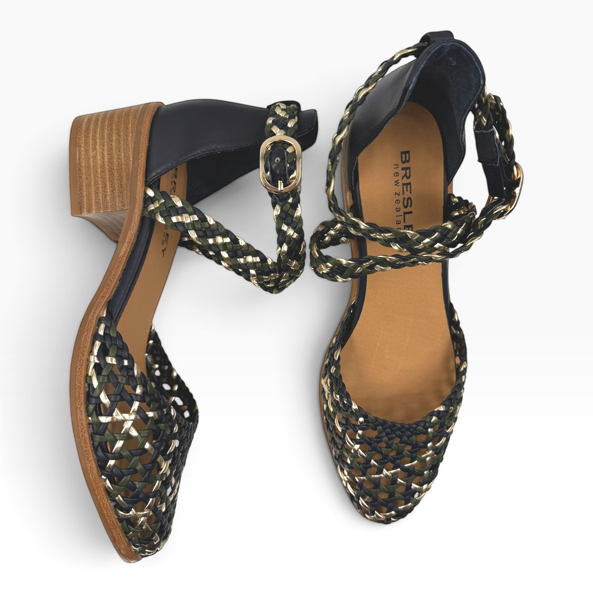 The Shoe Shop Anglo woven leather sandals in black, olive, and gold with a low block heel and ankle strap buckle.