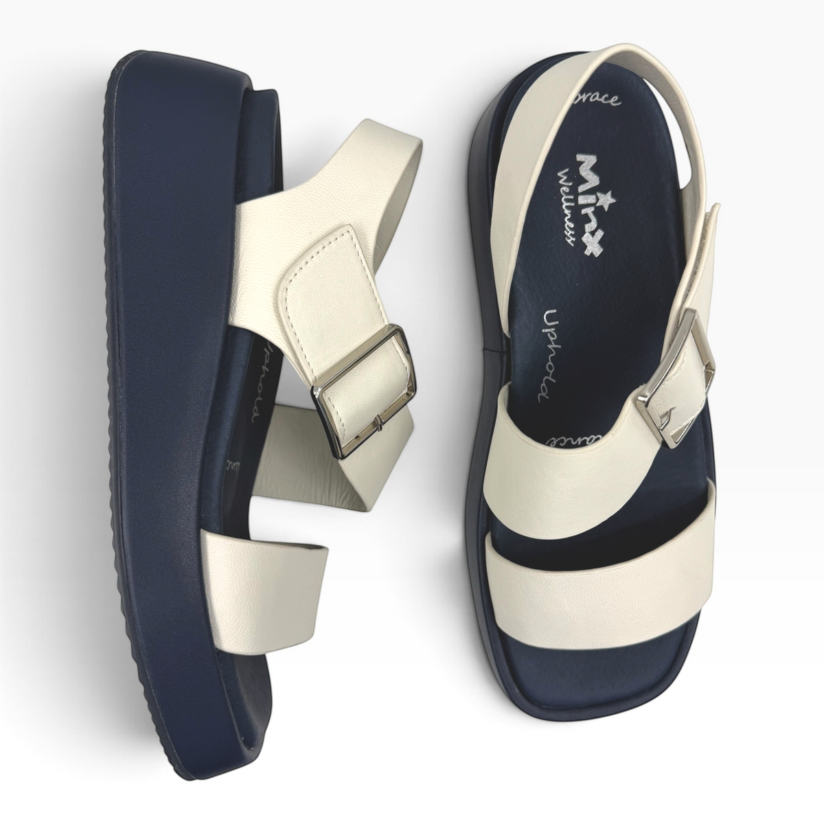 The Shoe Shop Zen platform sandals featuring cream leather straps, silver buckles, and a navy blue contoured sole.
